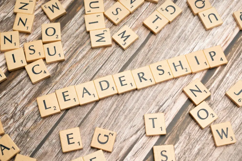 Scrabble tiles spelling out the word leadership on a wooden surface, illustrating leadership and management certification
